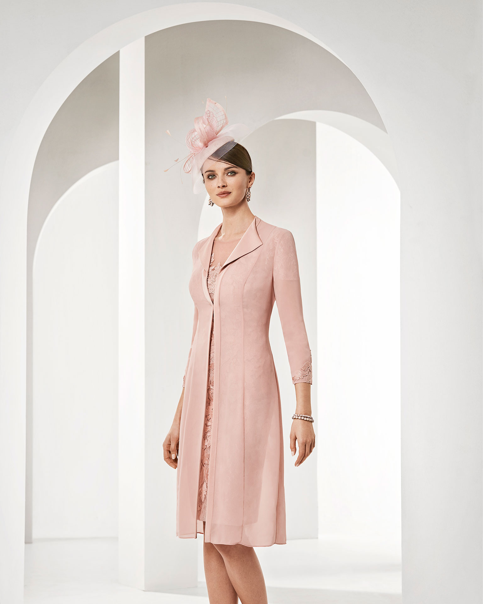 Vestido de fiesta corto en encaje. Con abrigo de georgette, cuerpo de encaje con pedrería, manga corta y escote barco. Colección COUTURE CLUB 2019.