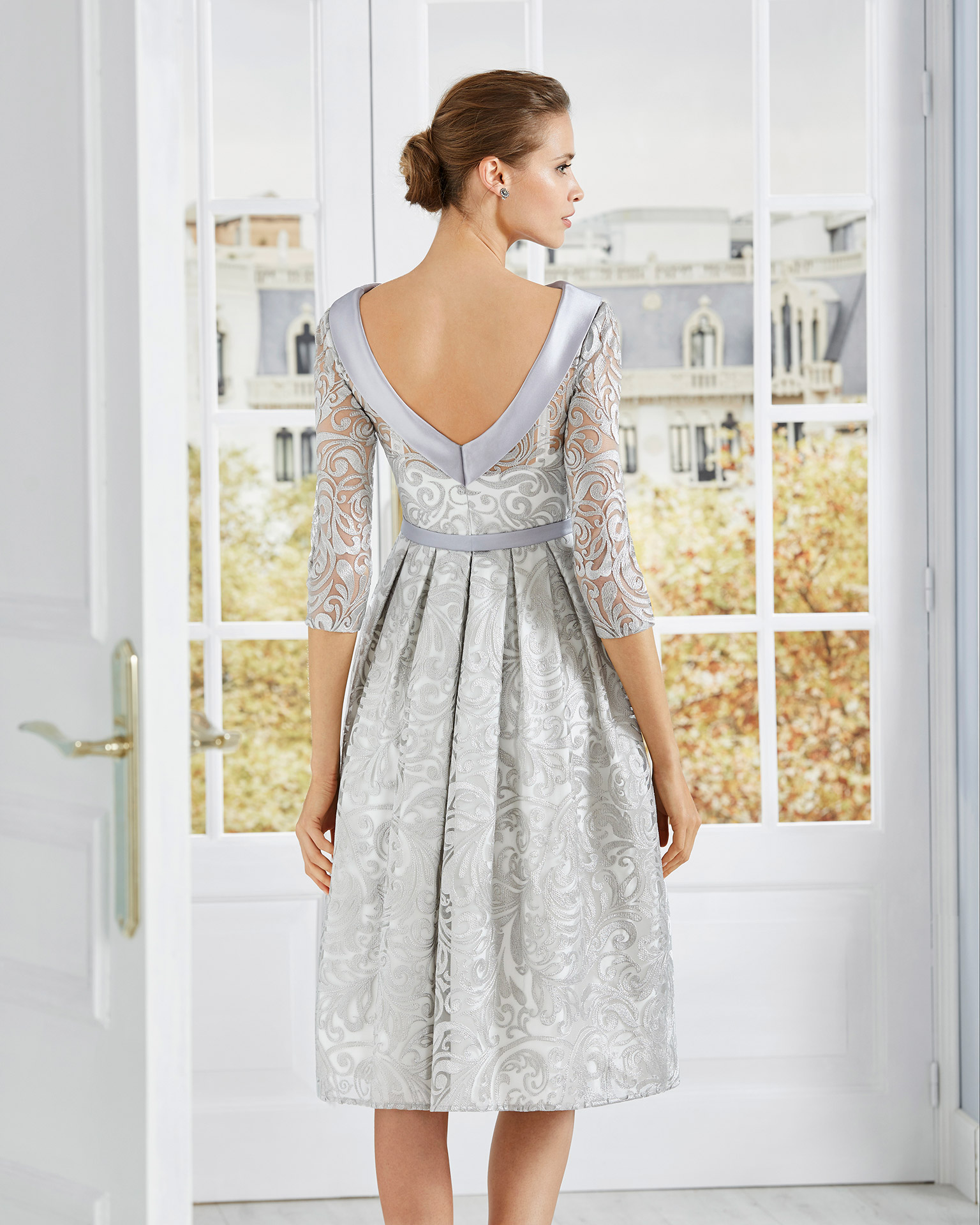 Short lace cocktail dress. Bateau neckline with three-quarter lace sleeves and bow at the waist. 2020 COUTURE CLUB Collection.