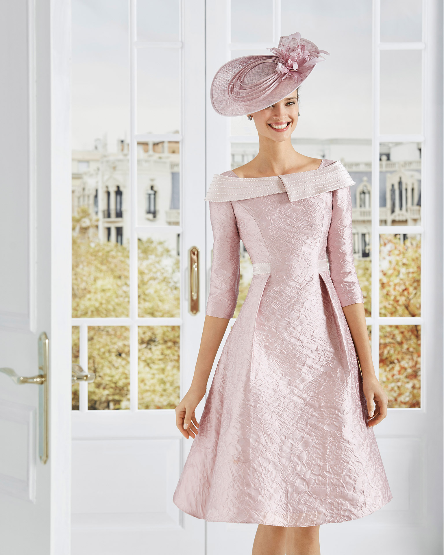 Vestido de fiesta corto en brocado con pedrería en el escote y cintura. Escote envolvente con mangas francesas. Colección COUTURE CLUB 2020.