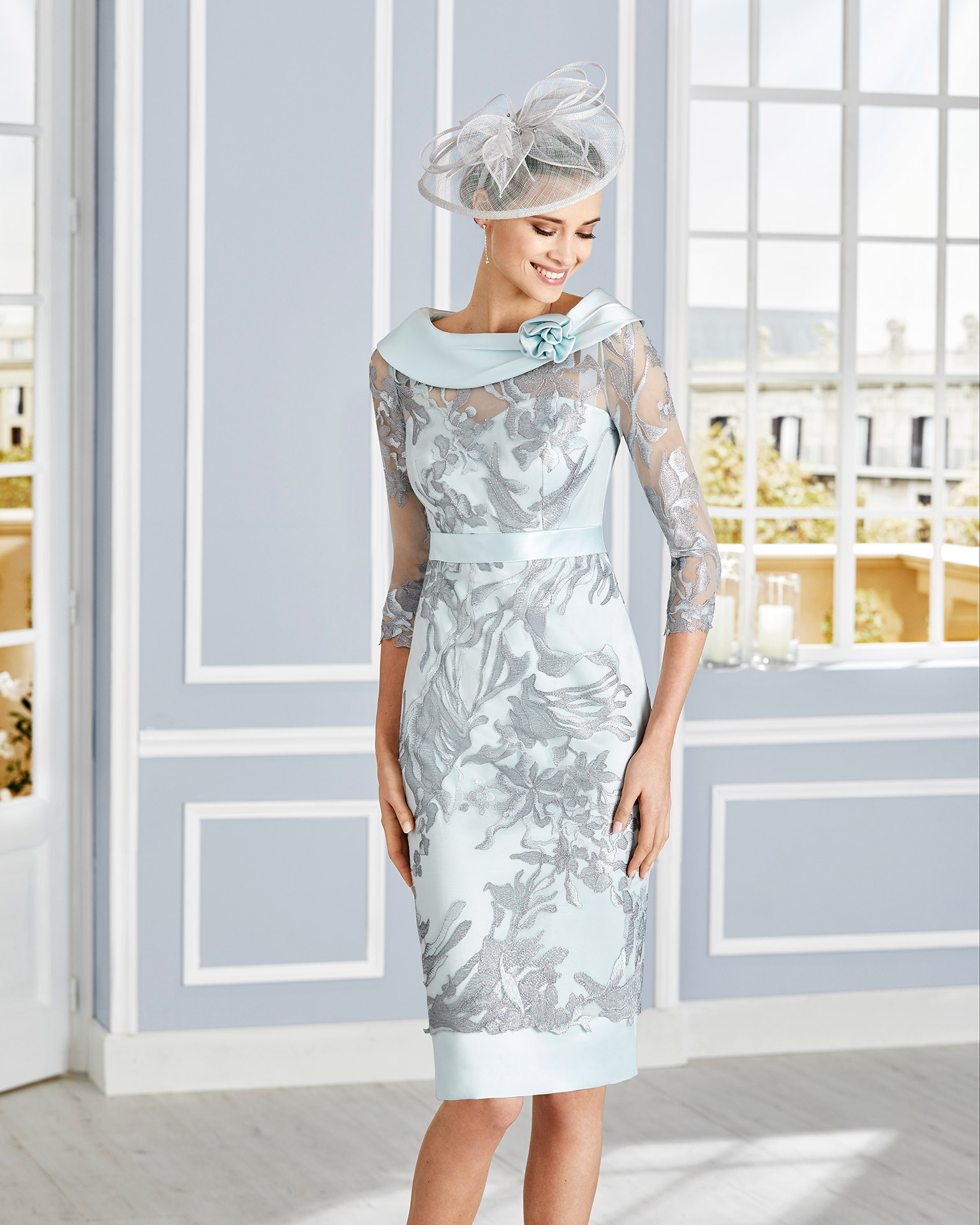 Short lace cocktail dress. Bateau neckline with three-quarter sleeves and sash. 2020 COUTURE CLUB Collection.