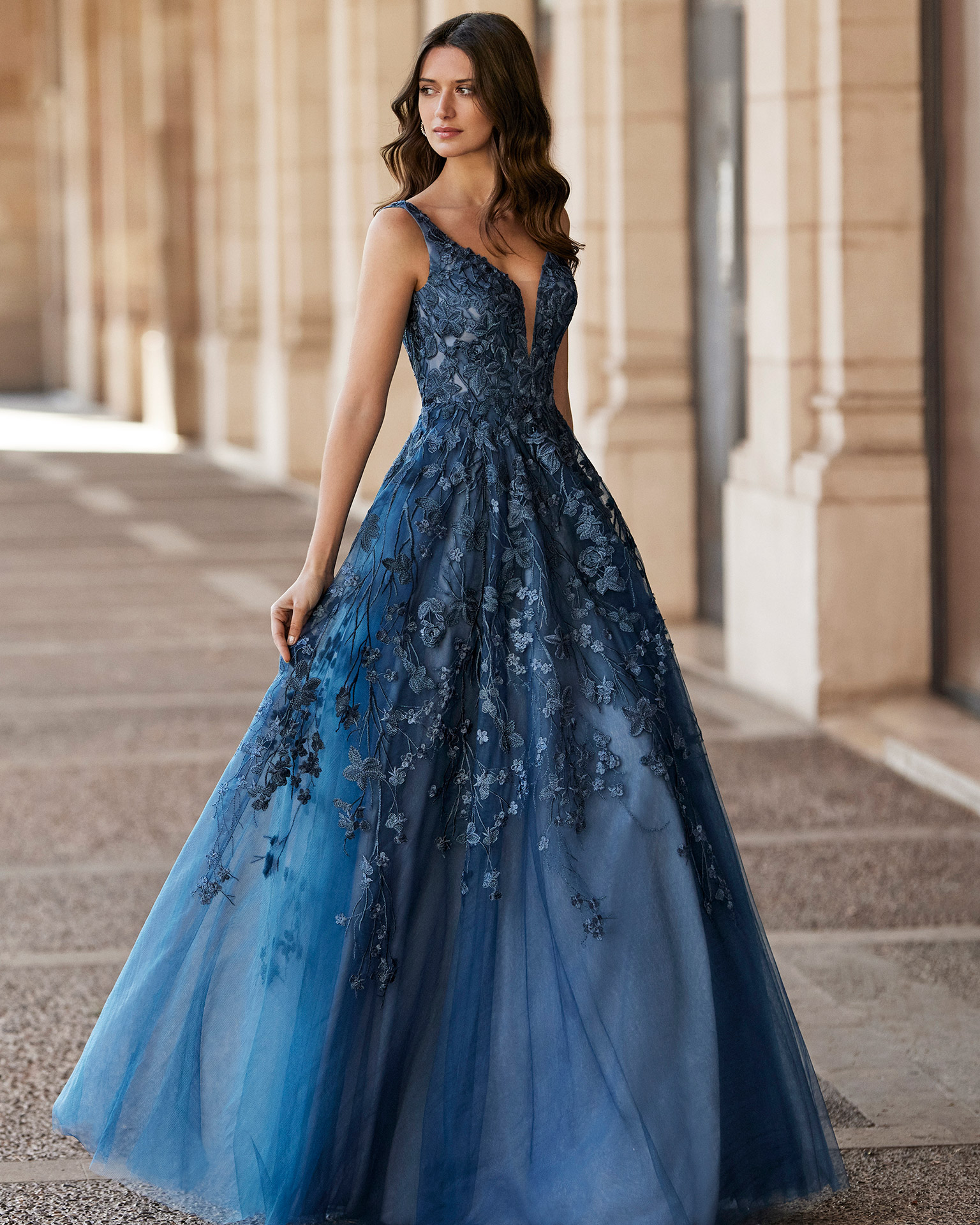 Long princess-style evening dress, made of tulle. Marfil Barcelona design with a lace bodice, a V-neckline, and an open back. MARFIL_BARCELONA.