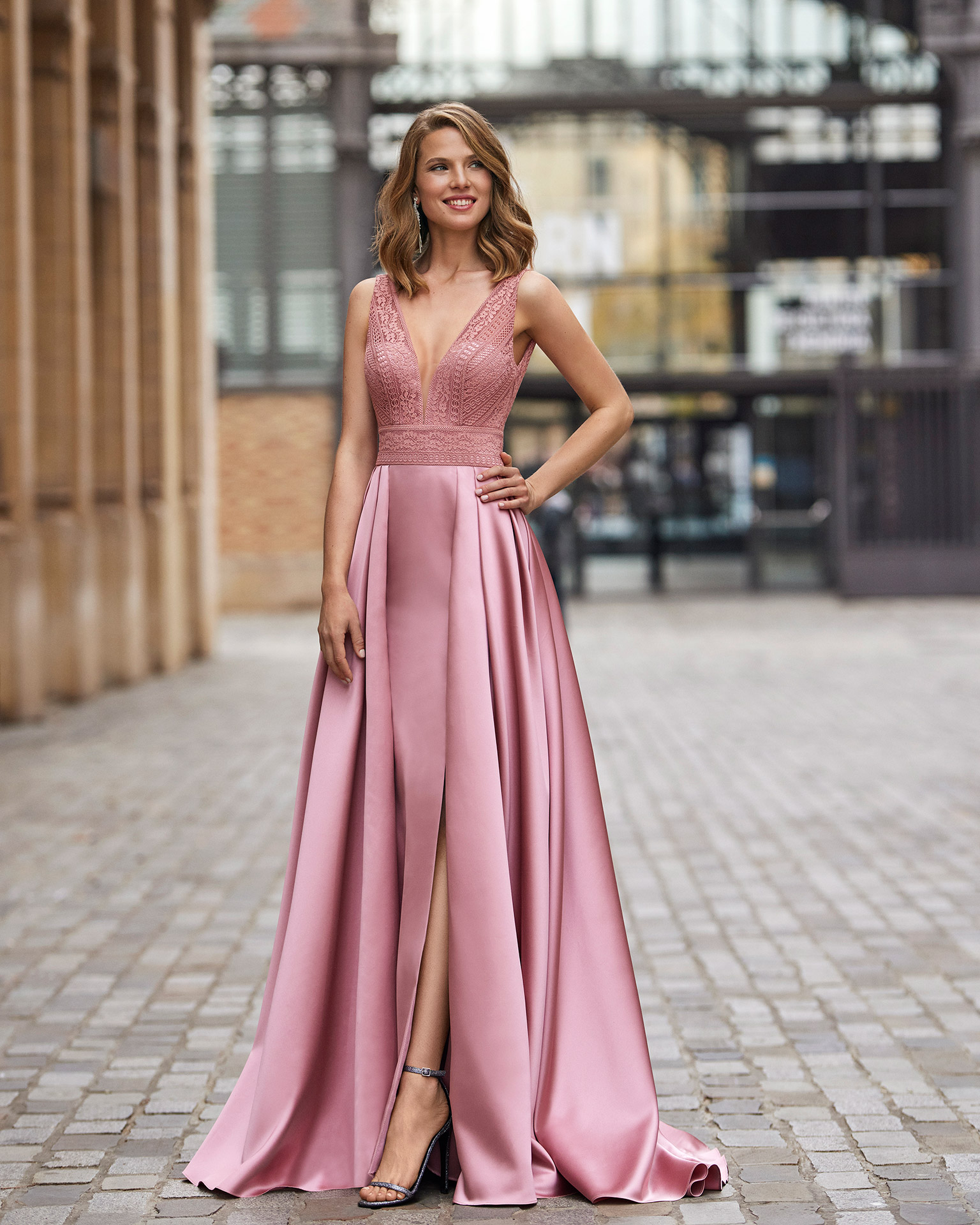 Long evening dress made of satin. Marfil Barcelona design with a lace bodice, a V-neckline, and a pleated skirt with a slit. MARFIL_BARCELONA.