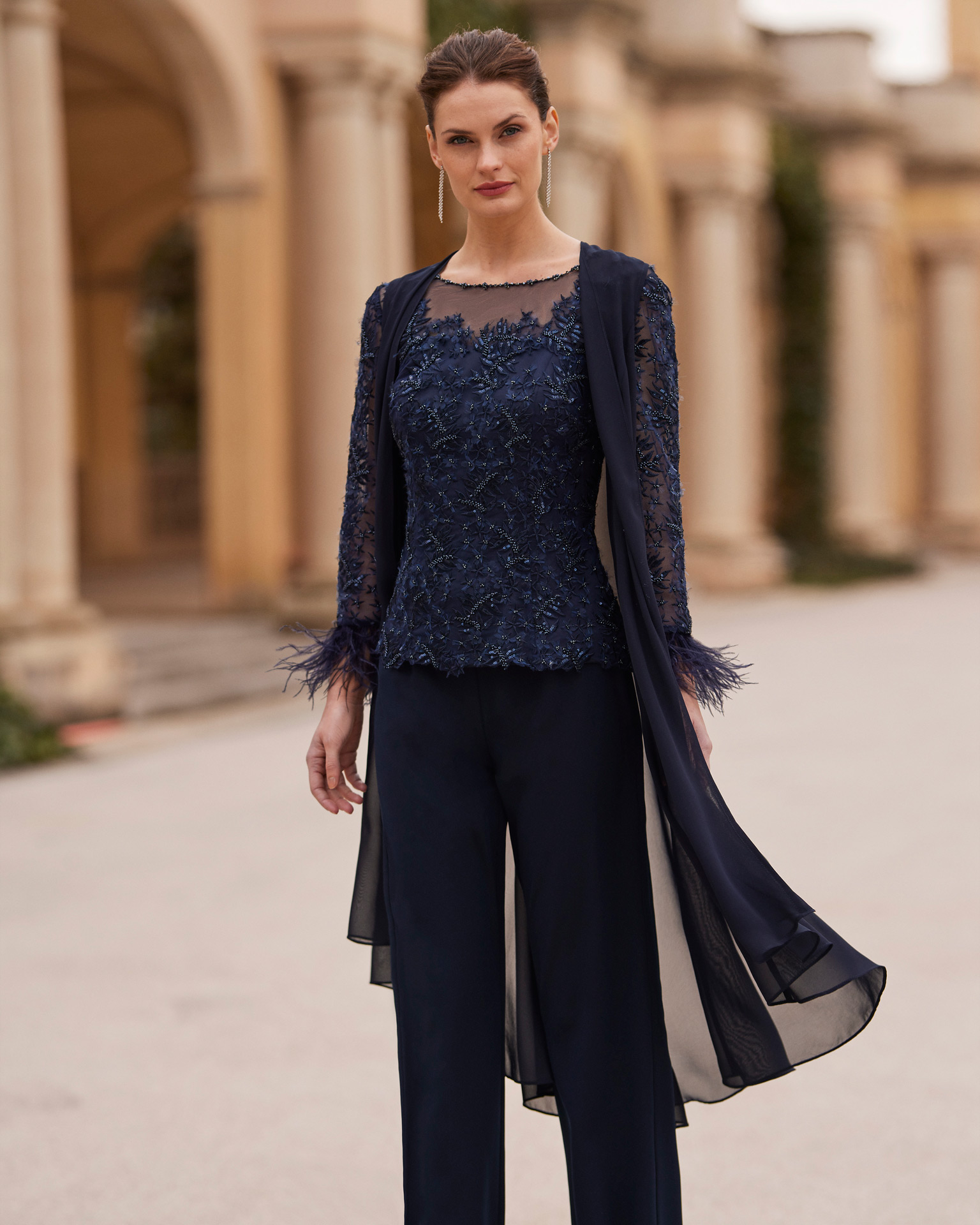 Modern evening pantsuit. Made with crêpe and beadwork lace. With bateau neckline and long sleeves with feathers, combined with jacket. Couture Club outfit. MARFIL_BARCELONA.