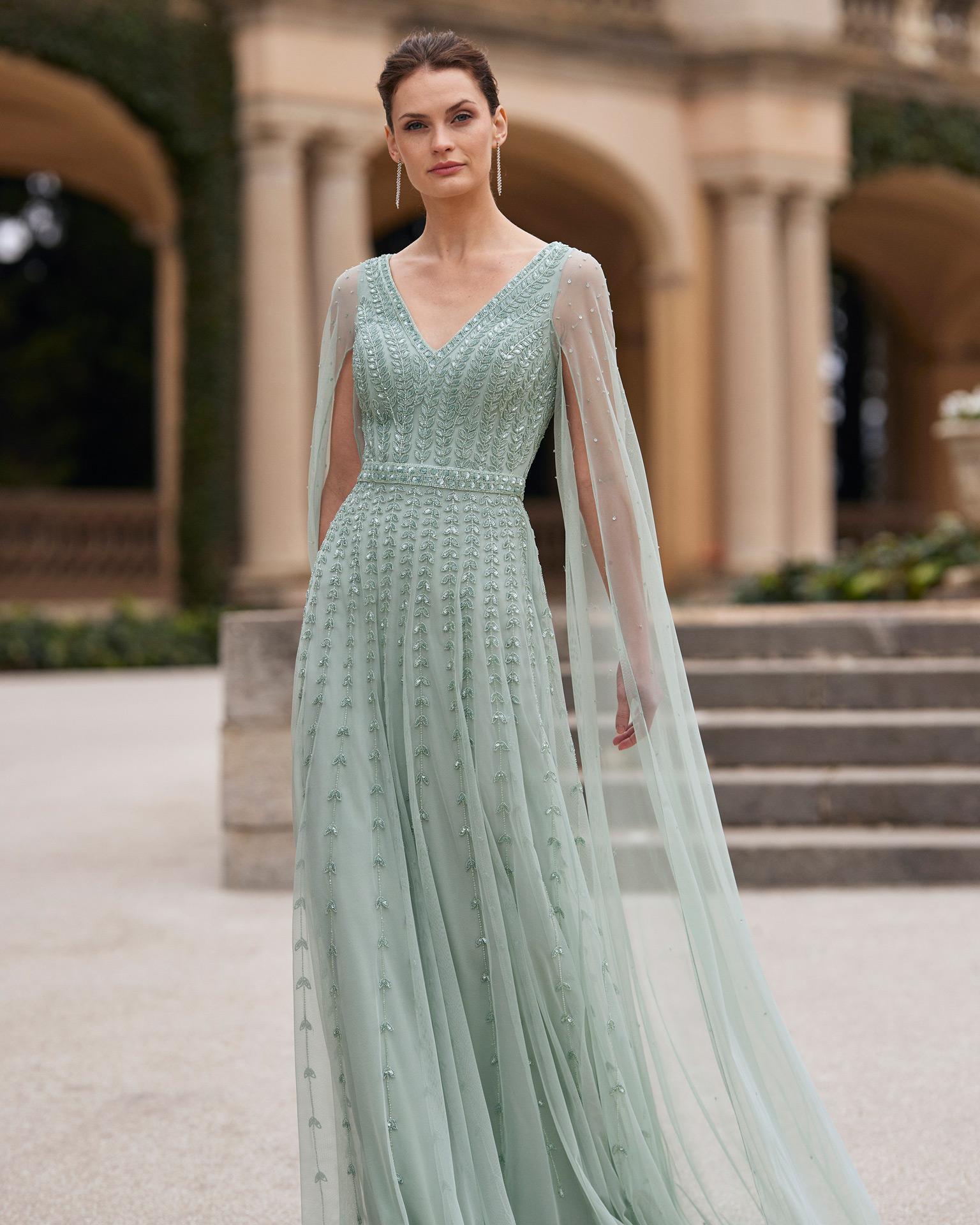 Elegant long cocktail dress. Made with beadwork. With V-neckline, zip back and cape sleeves. Couture Club design. MARFIL_BARCELONA.