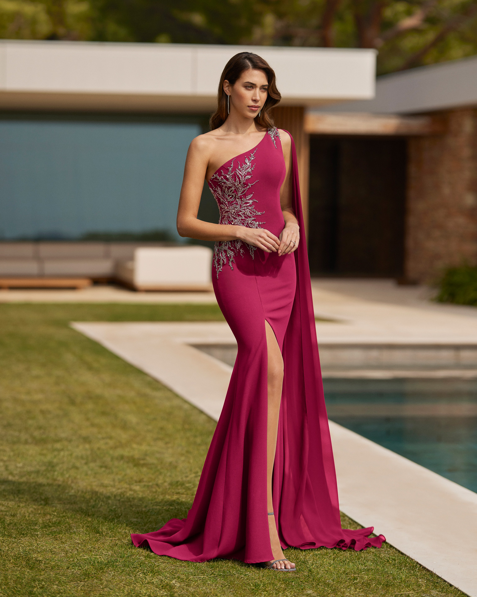 Elegant long gala dress. Made with crêpe embellished with beadwork. With asymmetrical neckline, closed back and cape. Marfil Barcelona on-trend look. MARFIL_BARCELONA.