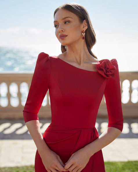 Abito da cerimonia lungo confezionato in crêpe satin. Con corpetto monospalla, schiena a V, maniche francesi e fiore decorativo. Modello Couture Club. MARFIL_BARCELONA.