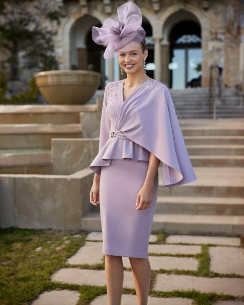 Short mother of the bride dress dress in crêpe. Featuring one shoulder cape and peplum. A Couture Club outfit. MARFIL_BARCELONA.