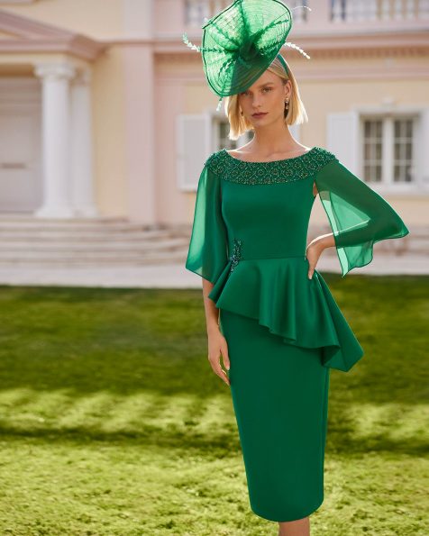 Abito da cerimonia corto confezionato in crêpe con applicazioni di strass. Con scollo a barchetta, schiena a V e maniche a mantella con applicazioni di strass. Modello Couture Club. MARFIL_BARCELONA.