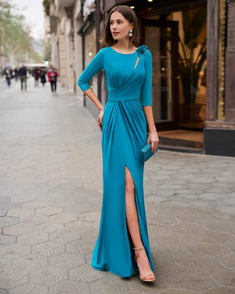 Modern long evening dress crafted in jersey with beadwork details. A bateau neckline and three-quarter sleeve complete the look. A Marfil Barcelona design. MARFIL_BARCELONA.