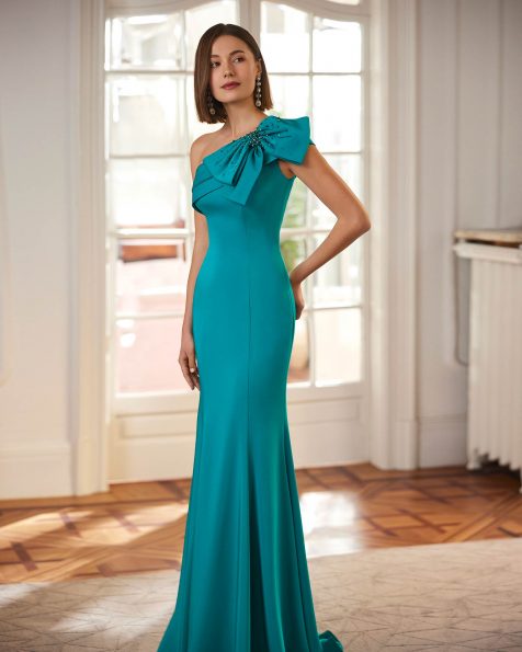 Elegant long cocktail dress crafted in satin crêpe with beadwork detailing. Featuring an asymmetric neckline and a shawl. A Marfil Barcelona design. MARFIL_BARCELONA.