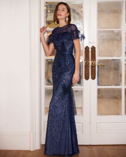 Long evening dress crafted in beadwork with feathers. Featuring a crew neckline, back zip and short sleeve. A Marfil Barcelona look. MARFIL_BARCELONA.