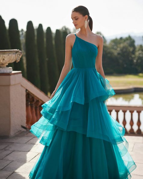 Long evening dress crafted in tulle. Showcase an asymmetric neckline, keyhole back, strap and flounced skirt. A Marfil Barcelona look. MARFIL_BARCELONA.