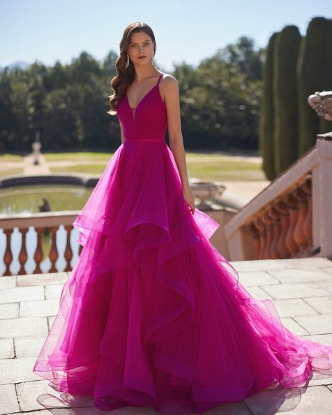 Long evening dress crafted in tulle. Showcase a V-neckline, back with crossed shoulder straps, and flounced skirt. A Marfil Barcelona look. MARFIL_BARCELONA.