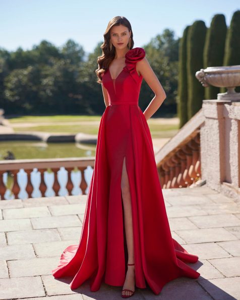 Two-piece long evening dress crafted in satin. Showcase a V-neckline and V-back, straps, an overskirt and a flower embellishment. A Marfil Barcelona look. MARFIL_BARCELONA.