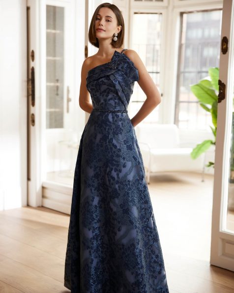 Long evening dress crafted in fil coupé. Showcase an asymmetric neckline, open back, straps and beadwork appliqués. A Marfil Barcelona look. MARFIL_BARCELONA.