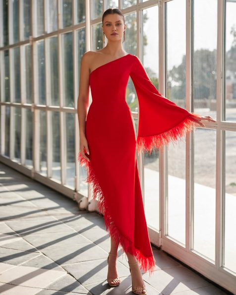 Long evening dress crafted in stretch crêpe with feathers. Featuring an asymmetric neckline, keyhole back, long sleeve and an asymmetric skirt with feathers. A Marfil Barcelona look. MARFIL_BARCELONA.
