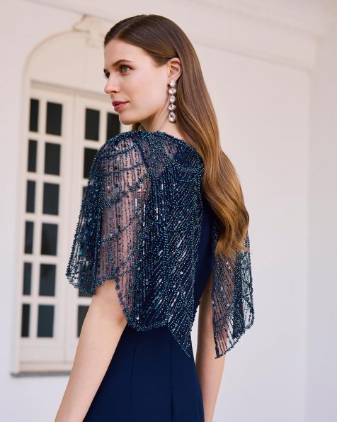 Abito da sera lungo in crêpe elasticizzato con perline. Scollo a barca, maniche a mantella e schiena decorata con perline. MARFIL_BARCELONA.