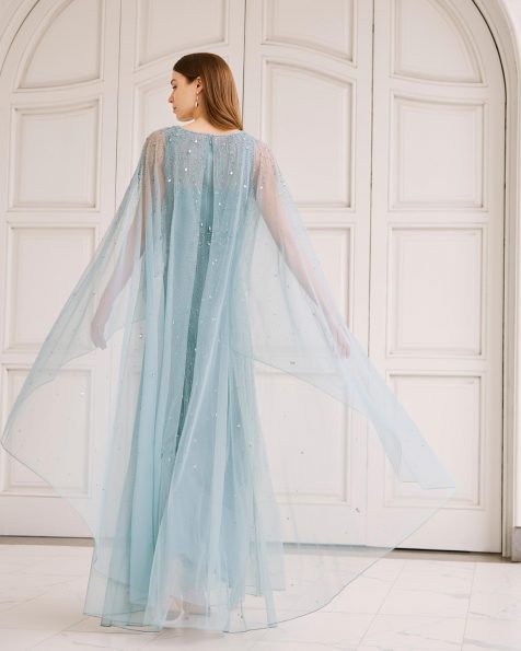 Vestido de fiesta largo, confeccionado en pedrería. Con escote barco, manga capa y espalda cerrada. MARFIL_BARCELONA.