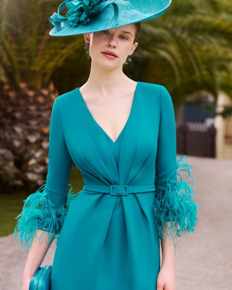 Vestido de fiesta midi, confeccionado en crepé con detalle de pedrería y plumas. Con escote pico, manga francesa, espalda con abertura y falda con abertura trasera. MARFIL_BARCELONA.