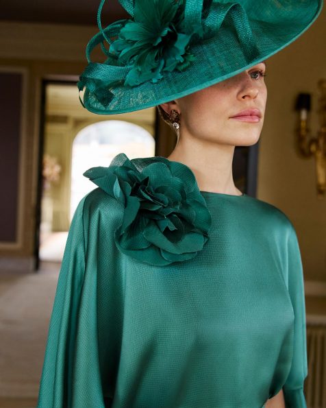 Abito da sera midi, in raso testurizzato. Scollo a barca, maniche a mantella, schiena chiusa e dettaglio floreale. MARFIL_BARCELONA.