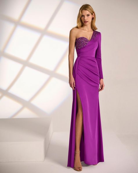 Vestido de fiesta largo. Confeccionado en crepé satén y pedrería. Escote asimétrico y manga larga. MARFIL_BARCELONA.