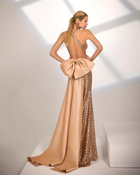 Abito da sera lungo. Realizzato in paillettes. Scollo halter e schiena scoperta. Fiocco sulla schiena. Include scialle. MARFIL_BARCELONA.