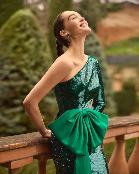 Vestido de fiesta largo. Confeccionado en lentejuelas. Escote asimétrico y manga larga. Cut-out en el cuerpo. Incluye chal. MARFIL_BARCELONA.