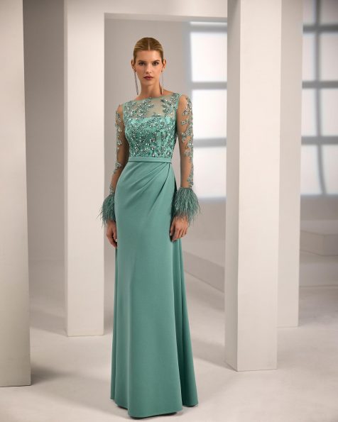 Vestido de fiesta largo. Confeccionado en crepé elástico. Cuerpo de pedrería. Manga larga con plumas. Espalda con abertura. Incluye chal. MARFIL_BARCELONA.